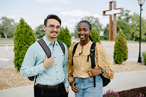 Picture of man and woman with cross in background.